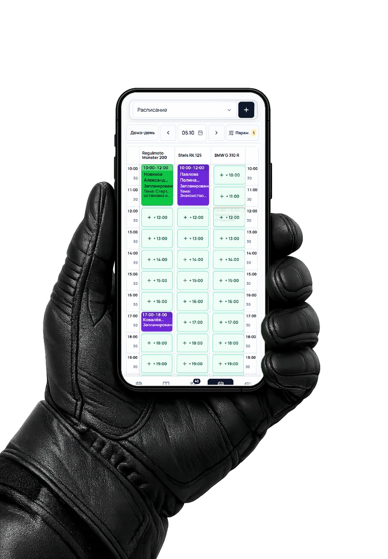 Рука в мотоперчатке держит телефон с мобильной версией MotoFlowX: расписание занятий по мотоциклам